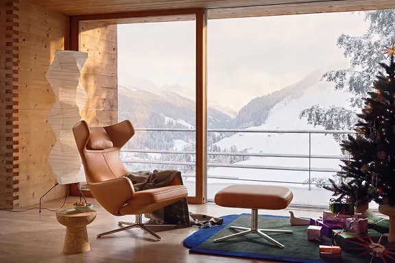 Brauner Lederloungesessel mit Ottoman vor Winterpanorama